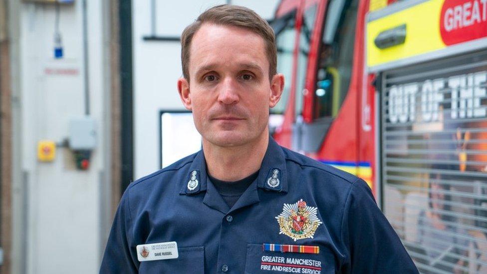 Fire chief Dave Russel in uniform by fire engine