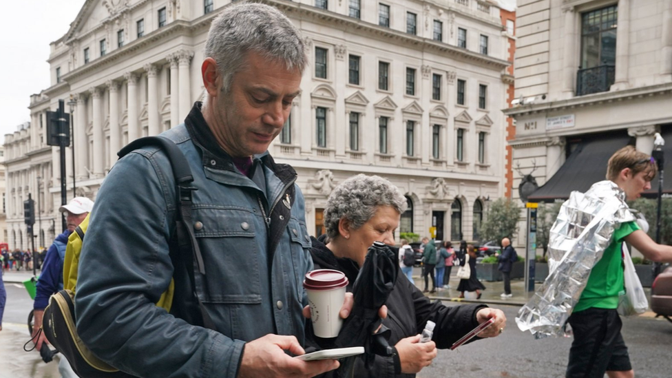 People looking at their mobile phones on Regent Street in London