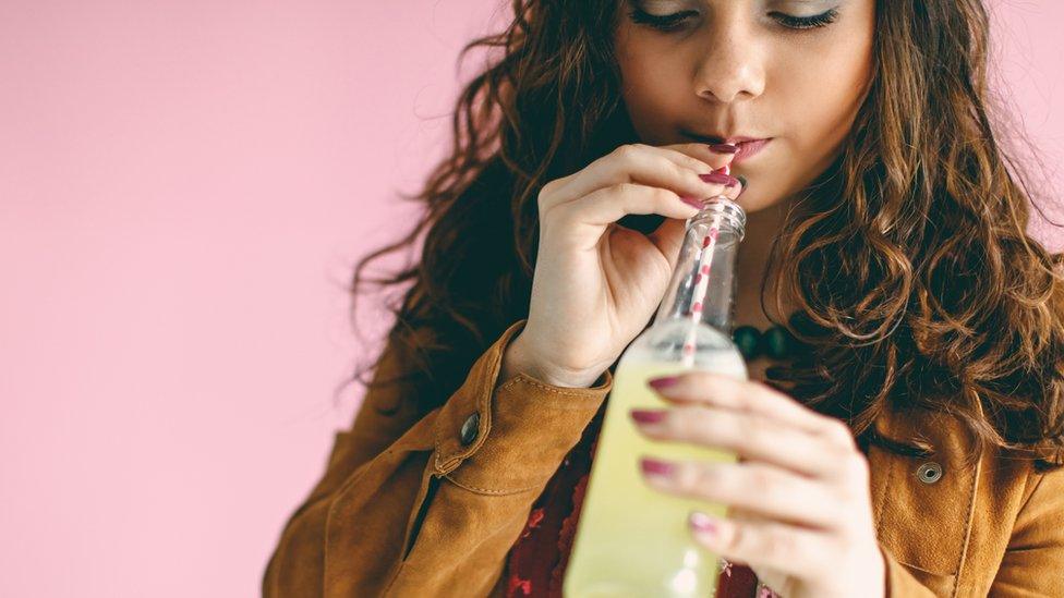 Woman drinking through a straw