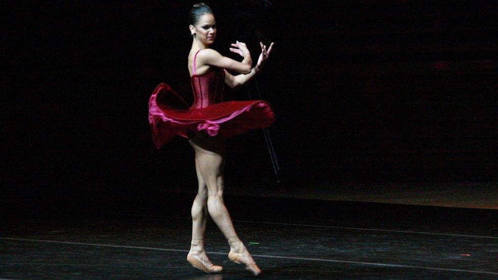 Misty Copeland dances wearing red velvet tutu