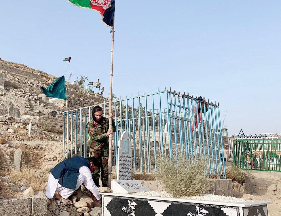 Zarifa Ghafari, Afghanistan's first female mayor, places a flag on her father's grave in Afghanistan