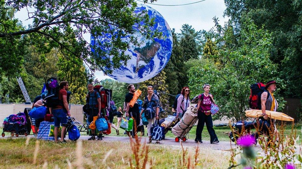 People walk past Luke Jerram's Gaia at Bluedot