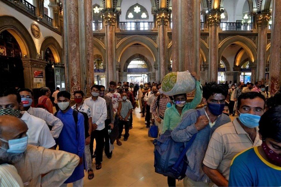 People wearing protective face masks wait in queues to buy train tickets at the Chhatrapati Shivaji Maharaj Terminus (CSMT) railway station after authorities resumed suburban train services for all commuters after it was shut down to prevent the spread of the coronavirus disease (COVID-19), in Mumbai, India, February 1, 2021.