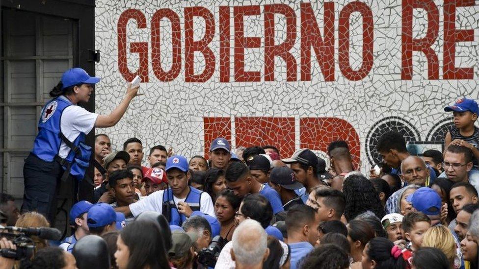 People queue to receive drums to collect water and water purification tablets from members of the Venezuelan Red Cross in Catia neighborhood in Caracas, Venezuela, on April 16, 2019.