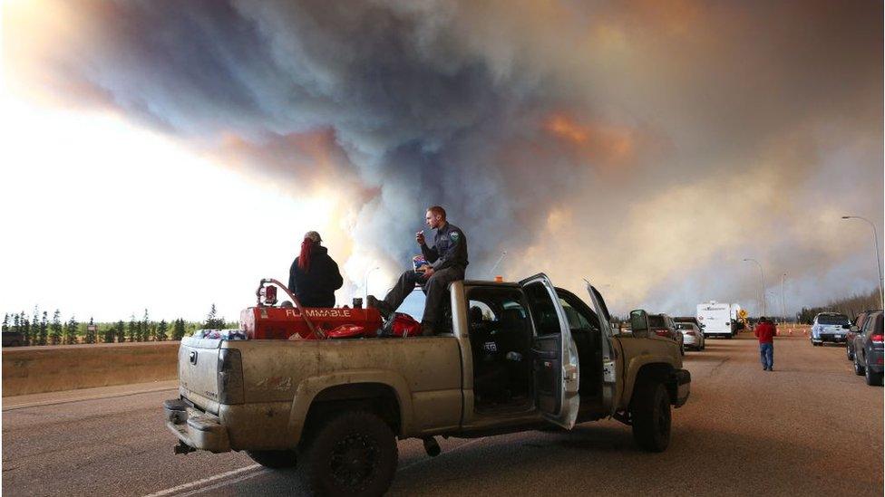 Smoke clouds rise over a rescue vehicle