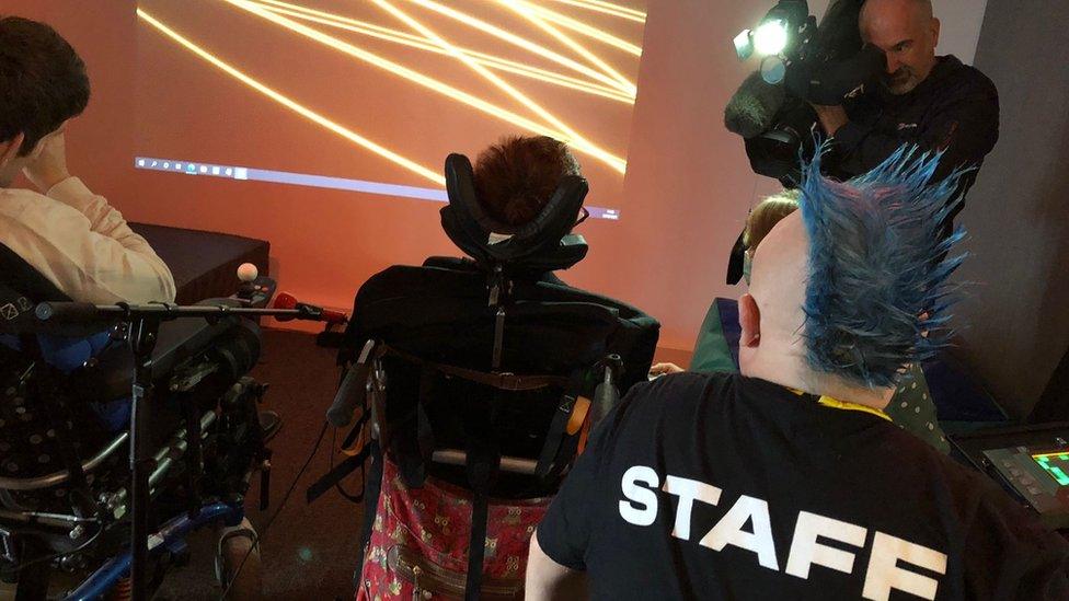 Two people in wheelchairs using the sensory room