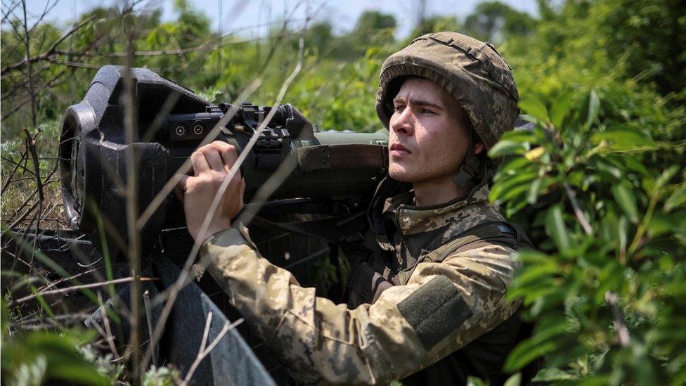 A Ukrainian service member holds a next generation light anti-tank weapon (NLAW)