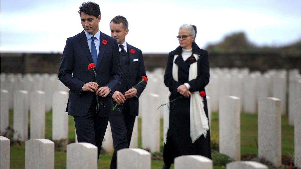 Canada's Prime Minister Justin Trudeau (L) and Canada's Veterans minister Seamus O'Regan (C) take part in a ceremony in tribute to Canadian soldiers killed during World War One at the Canadian National Vimy Memorial, 10 November 2018