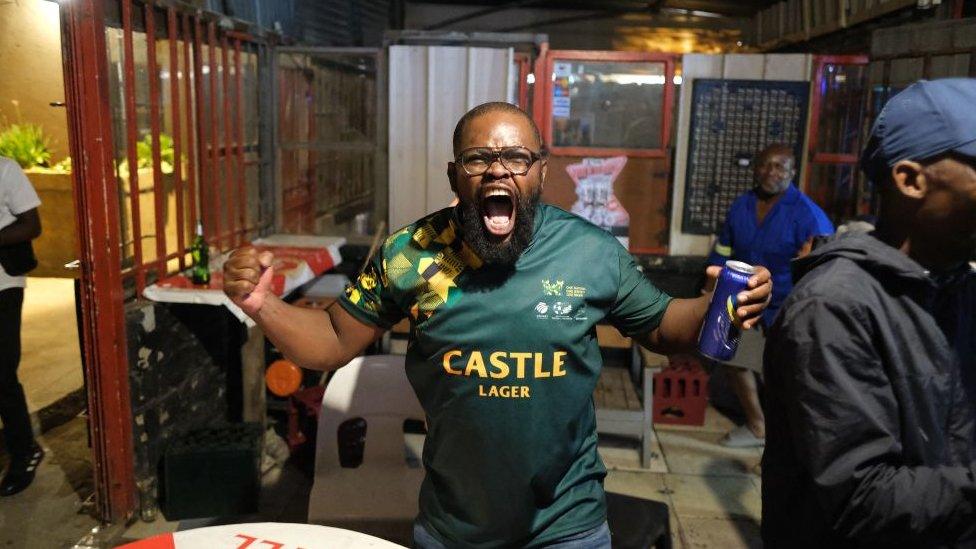 South African rugby supporters celebrate in Alexandra, near Johannesburg on October 28, 2023, after South Africa won the France 2023 Rugby World Cup final match between South Africa and New Zealand