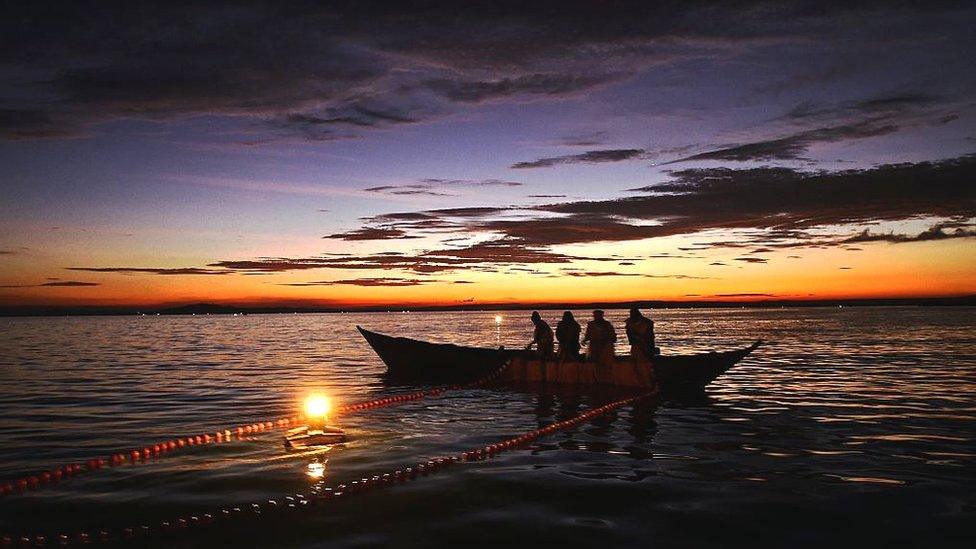 Fishermen on Lake Victoria as evening dalls