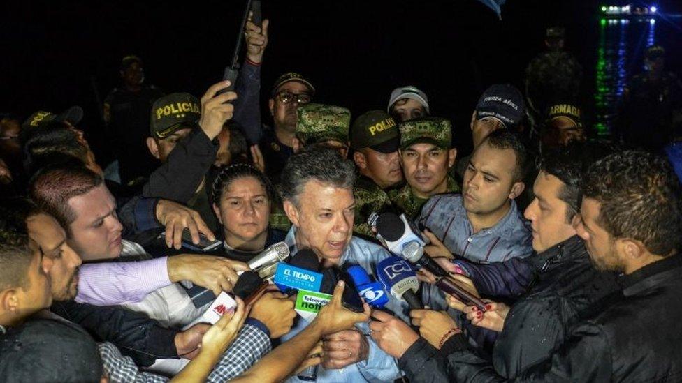 Colombian President Juan Manuel Santos (centre) answers questions from reporters