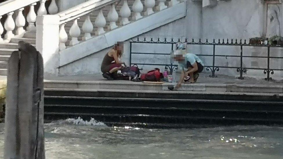 Tourists make coffee on side of river