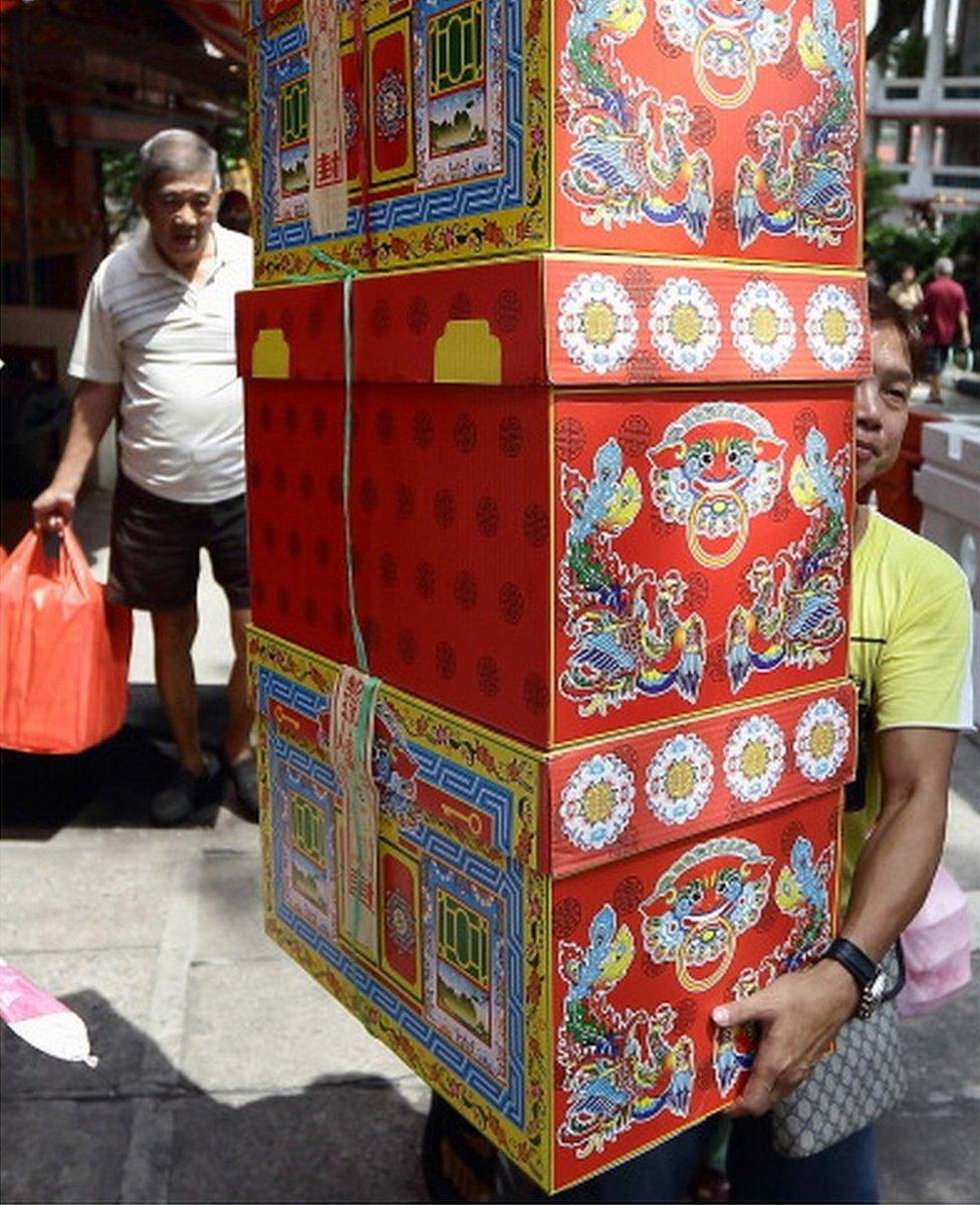 A man carries offerings at the Kong Meng San Phor Kark See Monastery during the Qing Ming Festival on 4 April 2013 in Singapore.