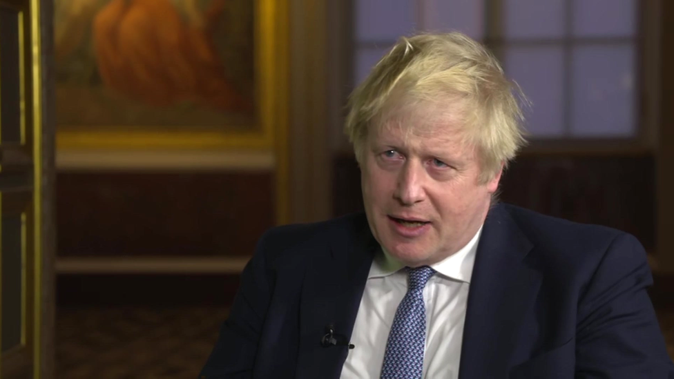 Boris Johnson sat down being interviewed