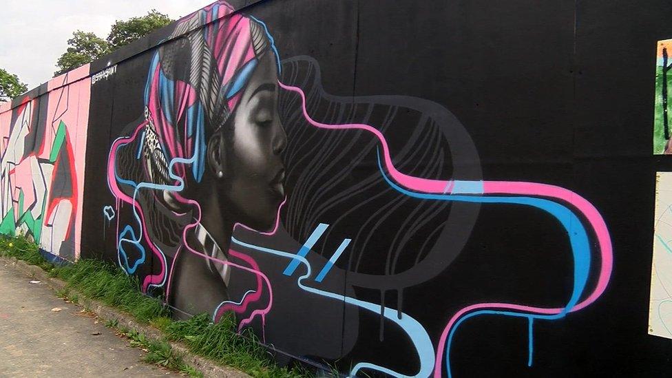 Street art design shows outline of woman's face on black background