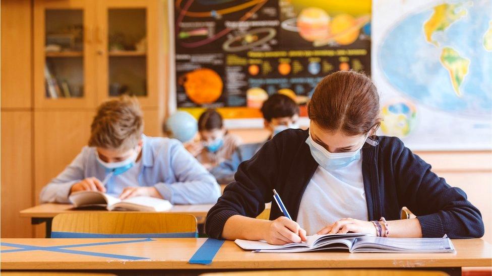 High school students at school, wearing face masks at desks