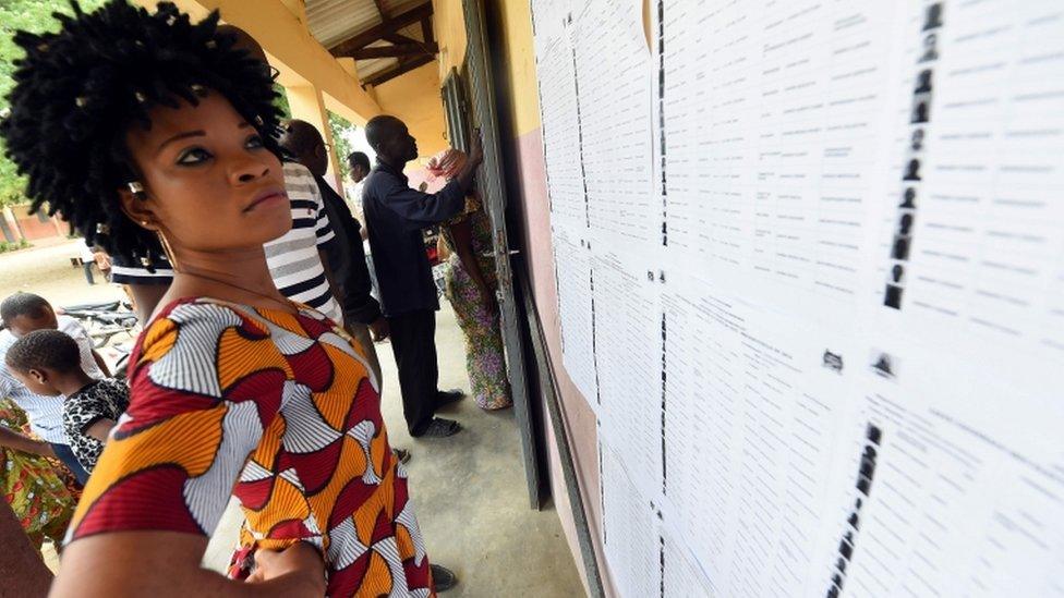 A woman checks details on a voters" list at a polling station in Cotonou, on March 6, 2016, during the presidential election. Benin went to the polls on March 6 to choose a new president from a crowded field of 33 candidates, but with concerns lingering about the distribution of voters" cards that already forced a two-week delay