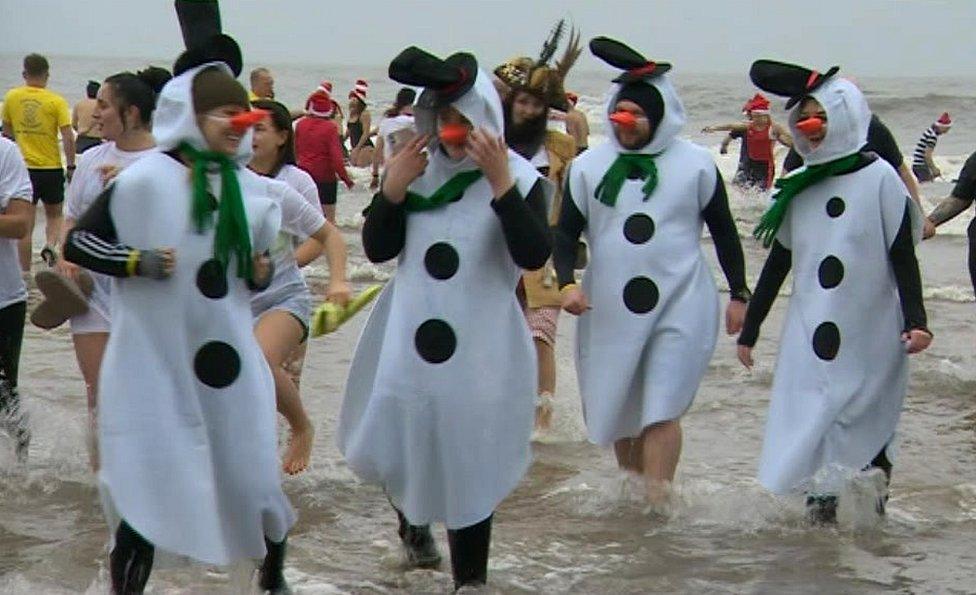 People dressed as snowmen in the sea