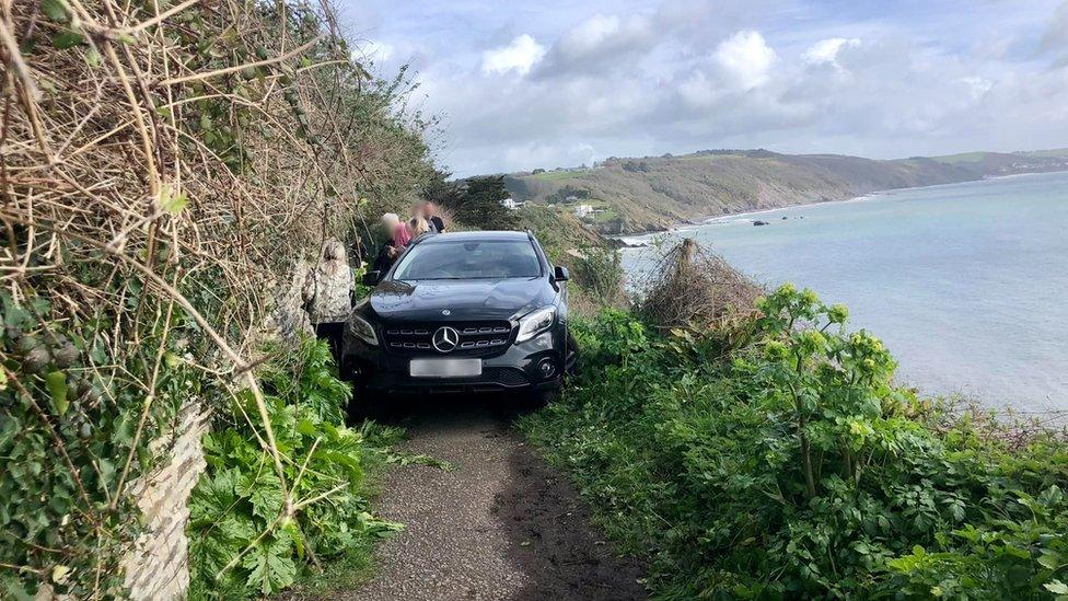 Black Mercedes car blocking cliff path