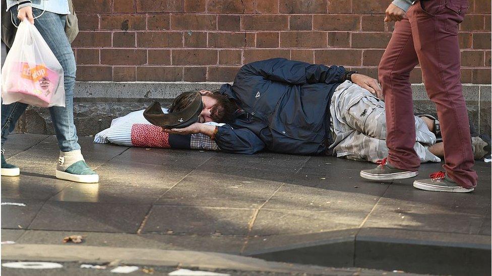 A homeless man begs for money on the streets of Sydney