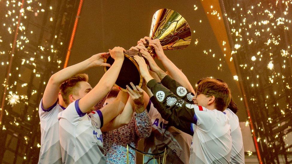 gamers holding a trophy