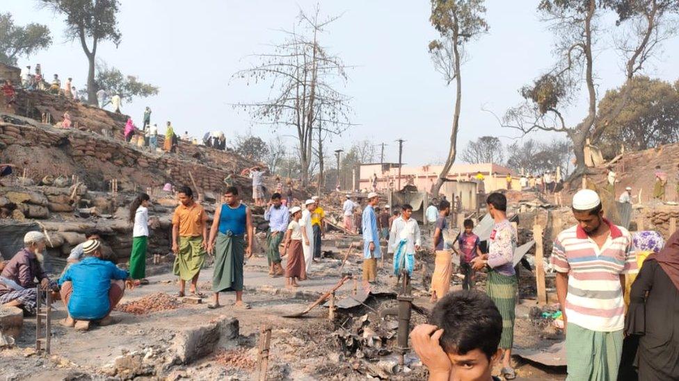 The community look at where their homes once stood