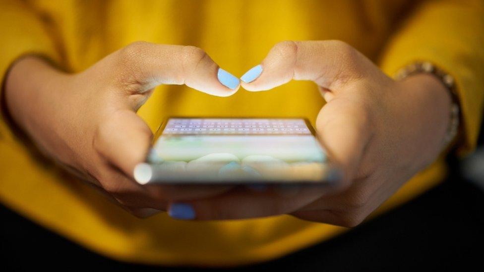 A woman uses a smartphone