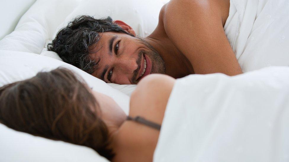 Man in bed looking happy