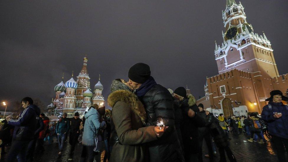 A young couple shares tender moments celebrating New Year on the Red Square in Moscow, Russia