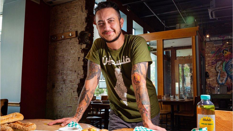 Marcelle Afram poses for a photo in a kitchen where he prepares food for his catering business