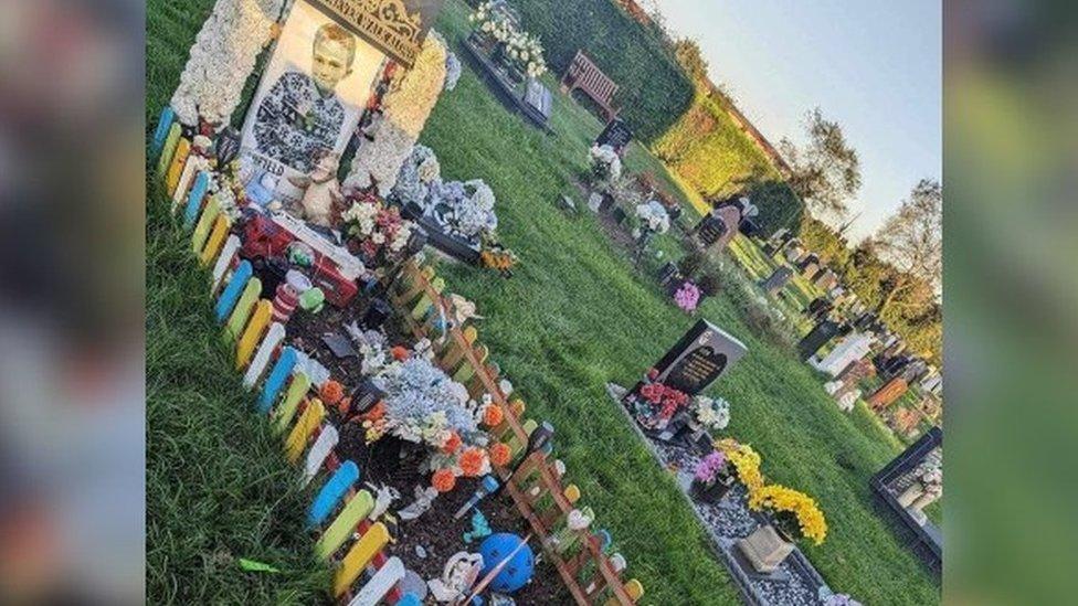 Harry-Lee's grave surrounded by low multicoloured picket fence