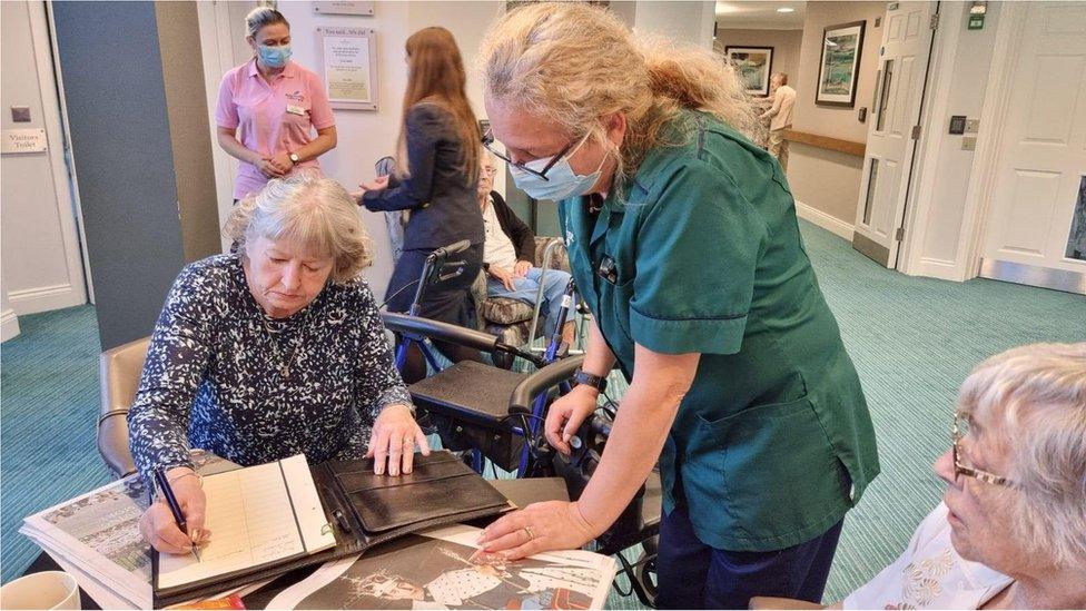 A photo of someone signing the book