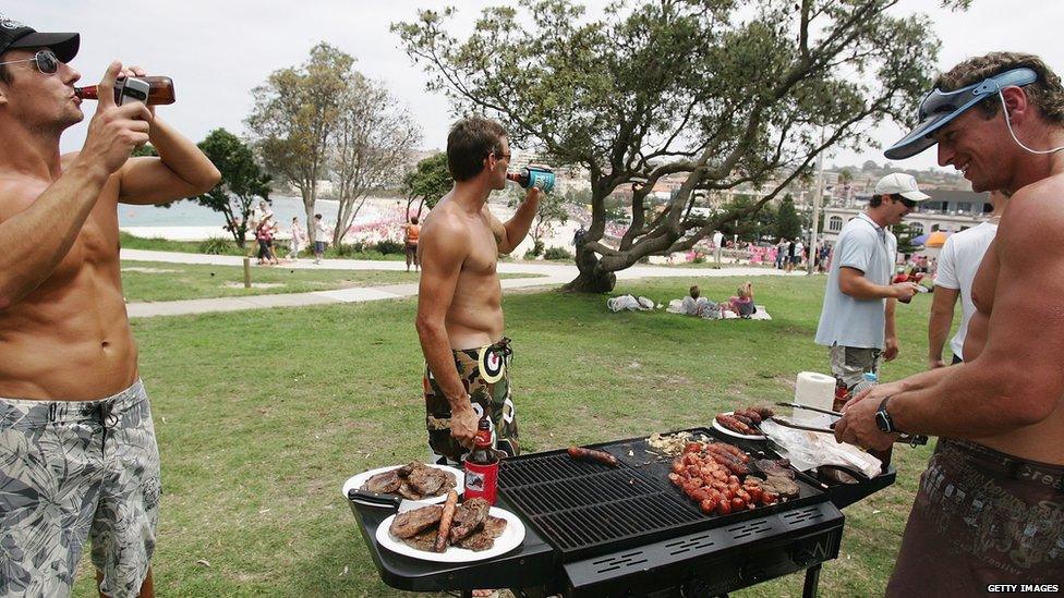 Men standing around a barbecue in Australia