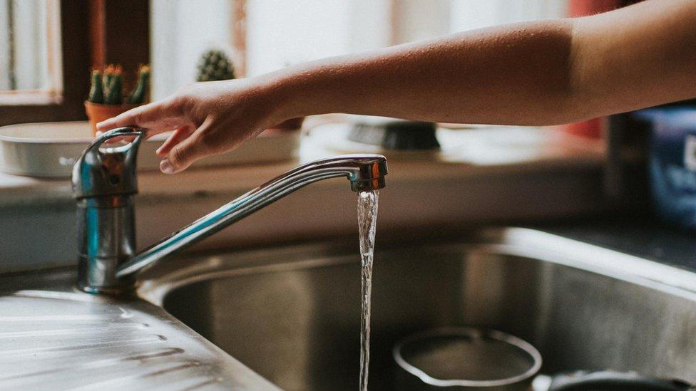 Woman reaching for tap