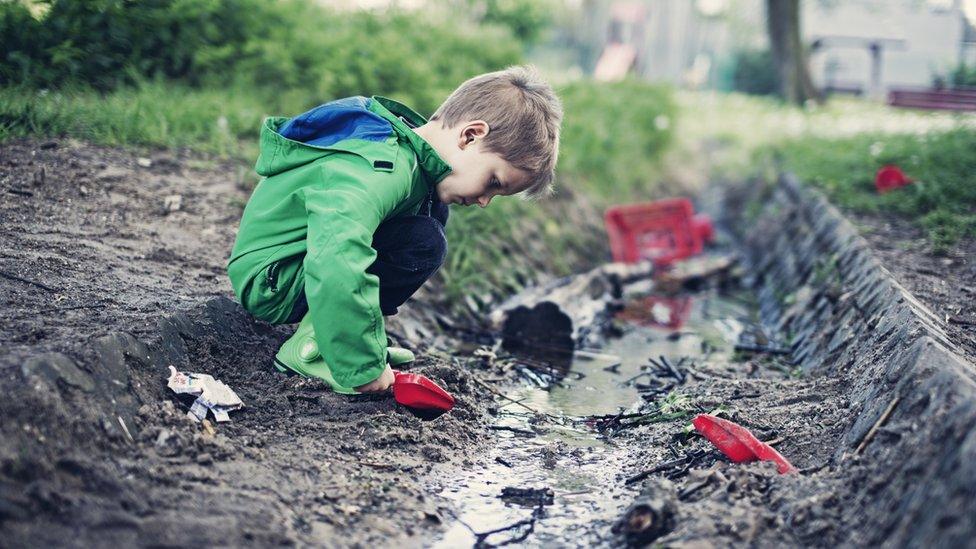 boy playing in mud