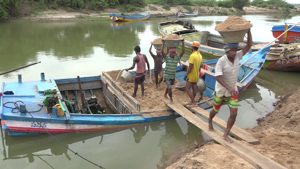 Men collecting sand from a river in Andhra Pradesh