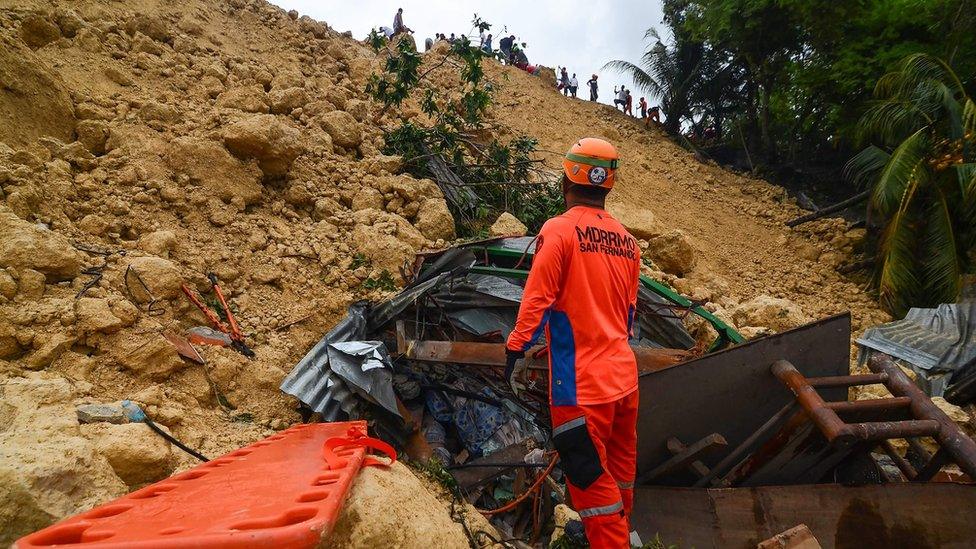 Rescue workers digging into rubble at the site of the landslide