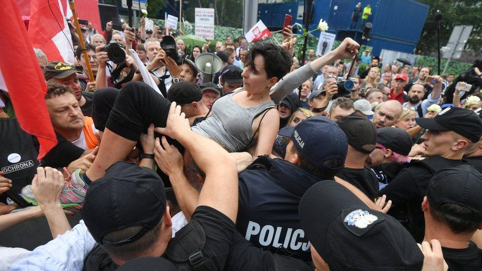 A protester is lifted above the crowd outside the Sejm building in Warsaw, Poland, 20 July 2017