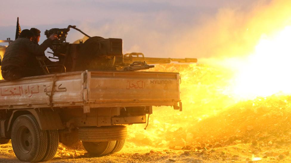 Rebel fighters fire a heavy machine gun at the government forces Al-Samman checkpoint on a road leading to Idlib near the Syrian city of Hama, on February 17, 2014