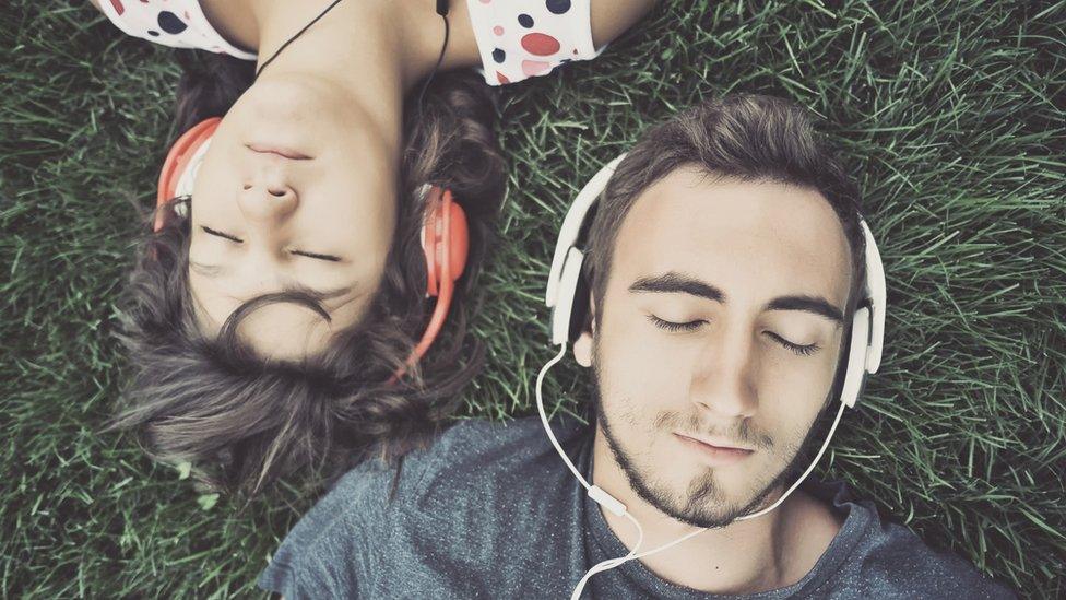 Couple listen to music on headphones