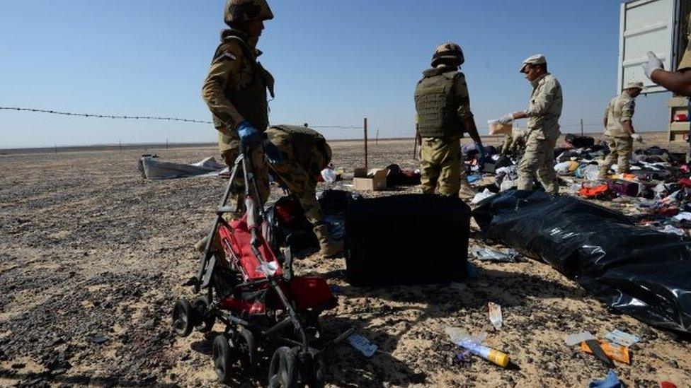 Egyptian soldiers collect personal belongings - including a pushchair - of plane crash victims at the crash site