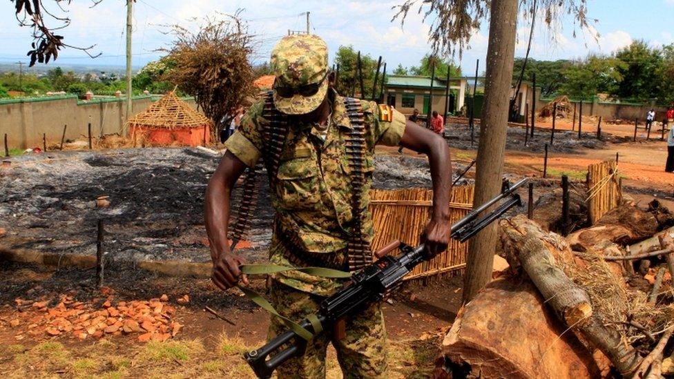 A soldier with a rifle walk around the burnt down royal palace