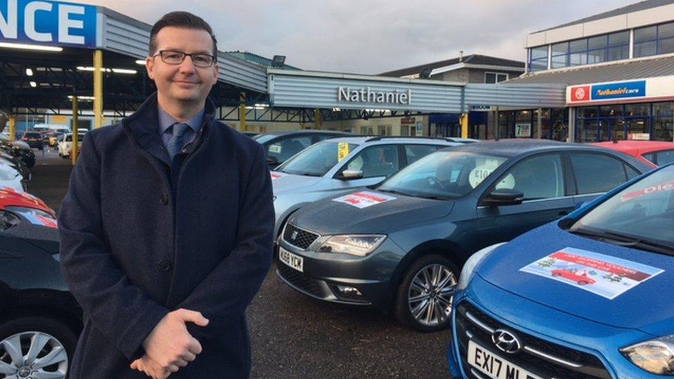 Car dealer Nathan Griffiths on lot of dealership in Bridgend, south Wales