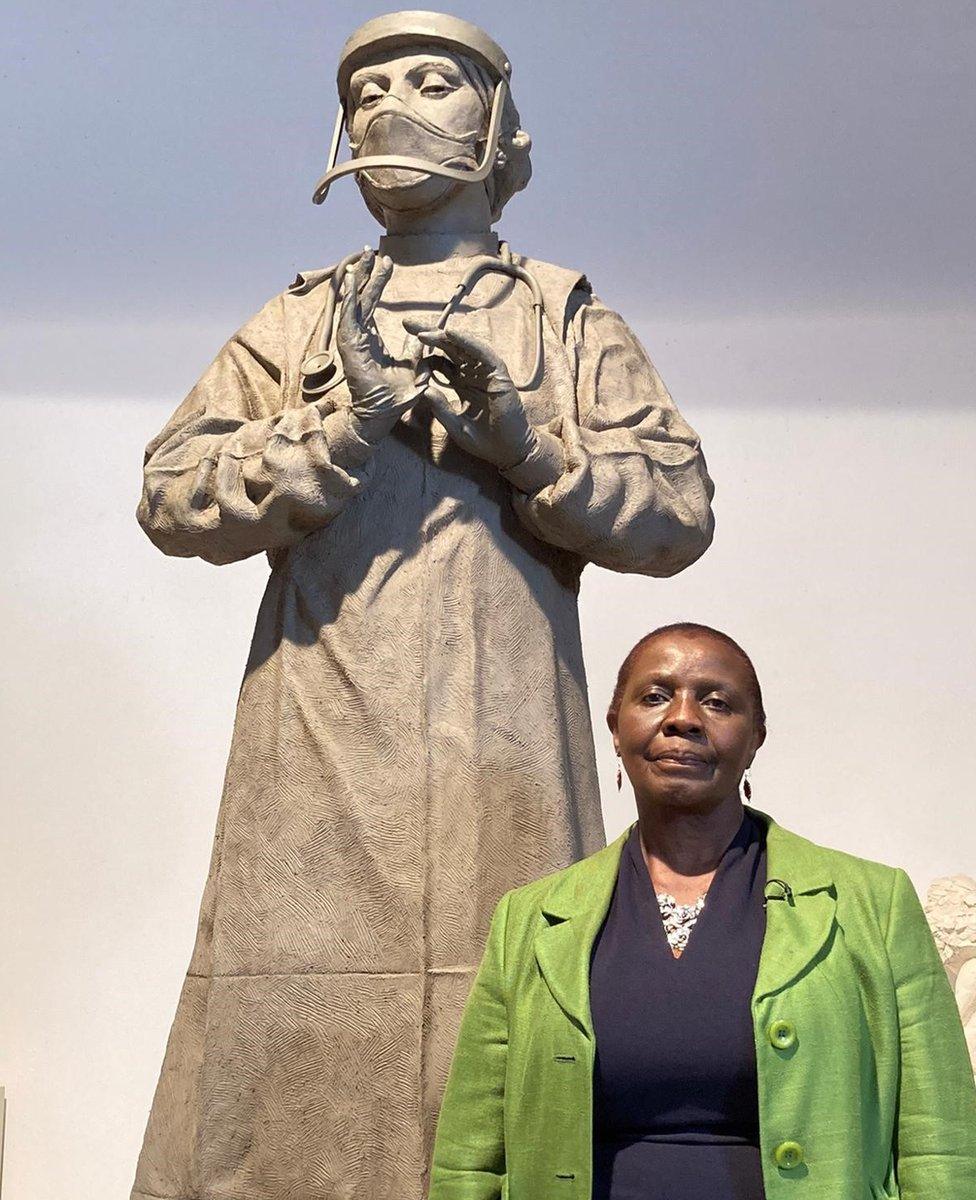 Nurse Nancy Jirira in front of statue of medic by sculptor Philip Jackson