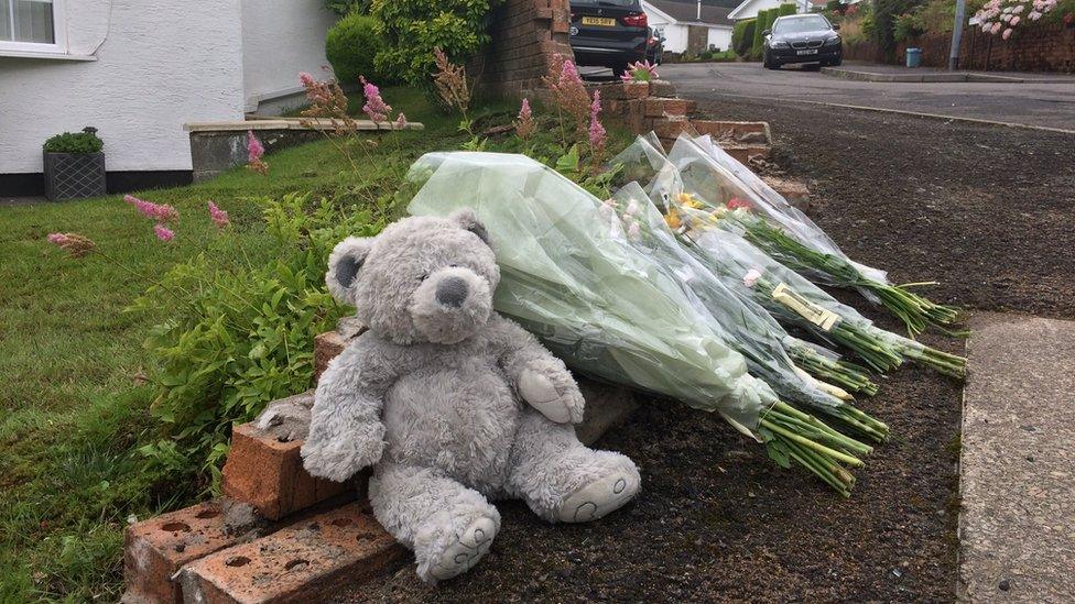 Flowers and a teddy bear at the scene of the crash