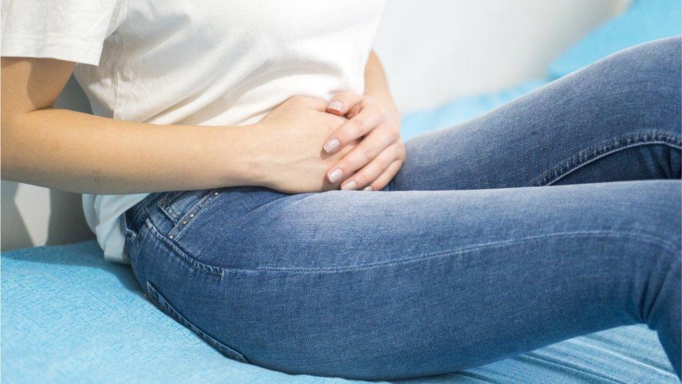 woman holding her abdomen in pain