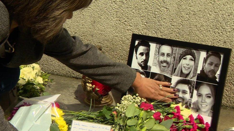 A family member touches the photo of her lost loved one