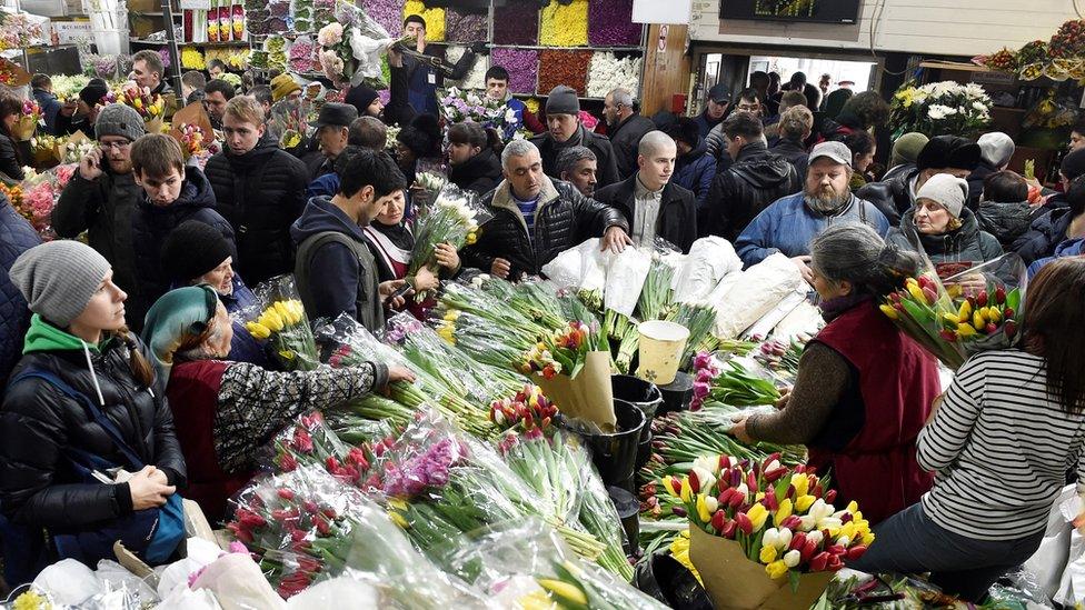 People buying flowers at a market in Moscow