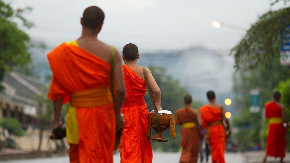 Monks getting donated food on the street of Luang Prabang, Laos