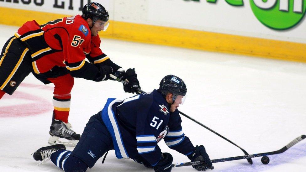 Winnipeg Jets" Andrew Copps (51) tries to control the puck from his knees has Calgary Flames" Kenny Agostino defends during the first period of an NHL hockey rookie game Friday, Sept. 11, 2015, in Penticton, British Columbia